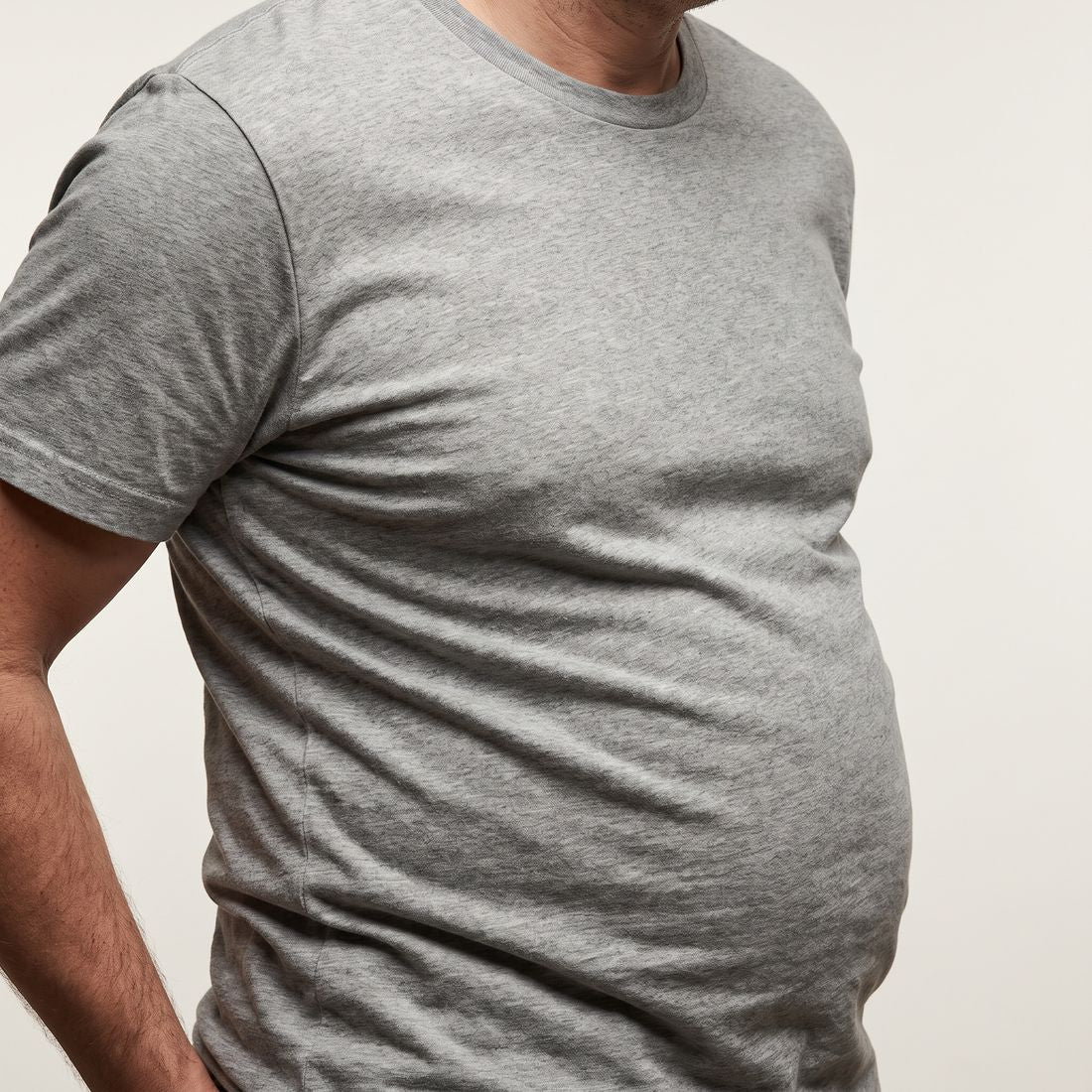 Close-up of a plain cotton t shirt bunching and creasing across the stomach